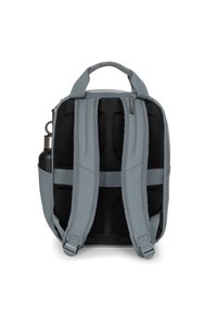 Mochila gris con correas ajustables y acolchadas, un asa superior, un bolsillo lateral para botellas de agua y un diseño elegante y minimalista.