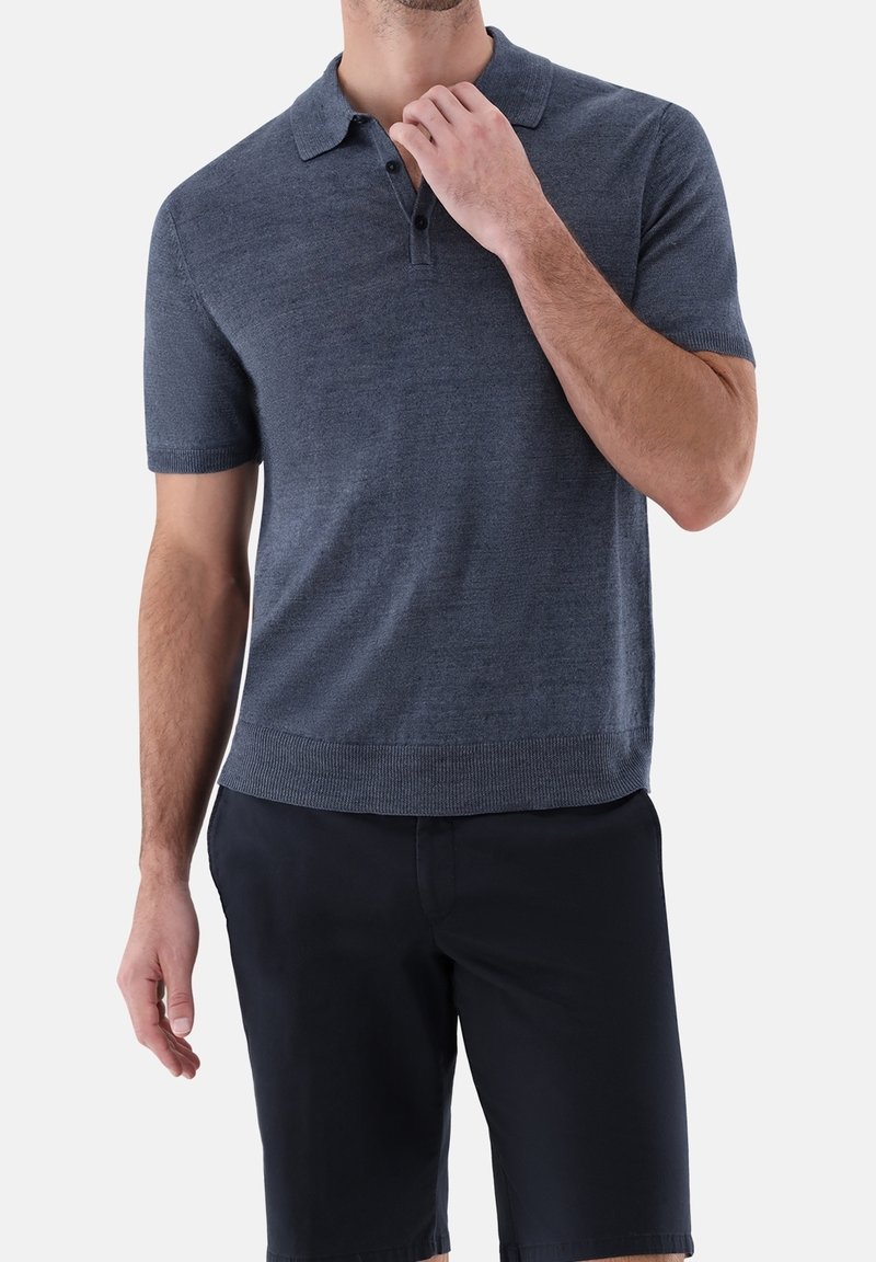 Námořnická modrá polo tričko s krátkým rukávem, límečkem, třemi knoflíčky a žebrovaným lemem. Vyrobeno z hladké, lehké látky.