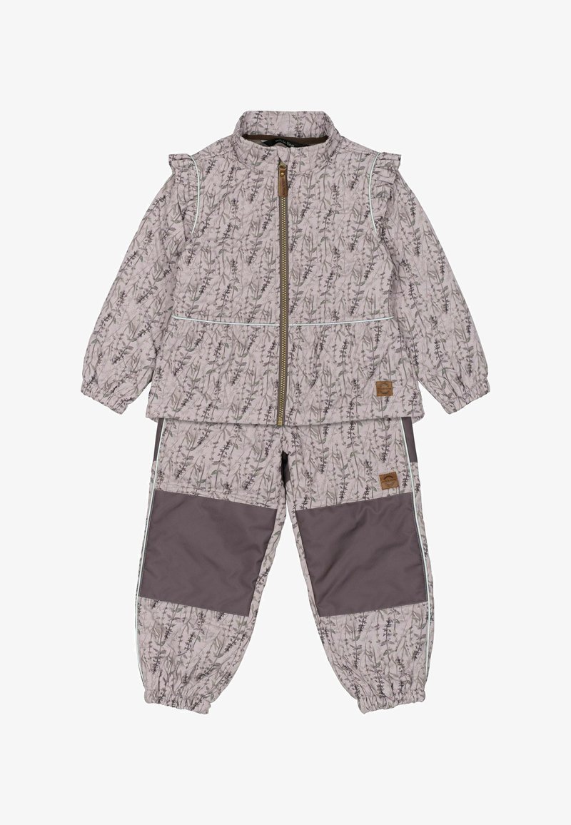 Chaqueta ligera de estampado rosa con cierre de cremallera y hombros con volantes, combinada con pantalones oscuros de cintura elástica con acentos laterales.