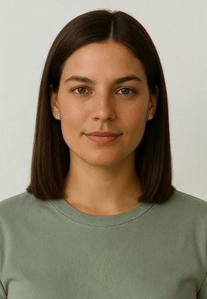 Grünes Baumwoll-T-Shirt mit Rundhalsausschnitt, glatter Textur, getragen von einer Person mit glatten braunen Haaren. Kleine Friedenssymbol-Ohrringe sichtbar.