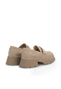 Beige suède loafers met een dikke, bruine, gestructureerde zool. Heeft een decoratieve zilveren rand langs de zool voor extra detail.