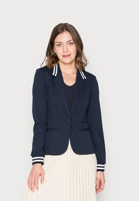 Blazer navy con un design aderente, colletto e polsini a righe, chiusura con un bottone e due tasche frontali. Tessuto morbido con una texture liscia.