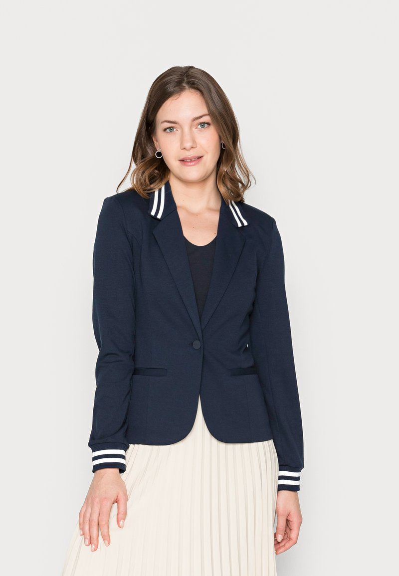Blazer navy con un design aderente, colletto e polsini a righe, chiusura con un bottone e due tasche frontali. Tessuto morbido con una texture liscia.