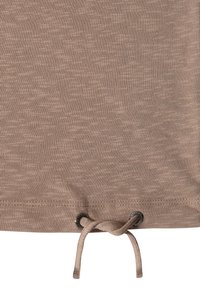 Tissu beige avec un ourlet comportant deux œillets en métal à travers lesquels passe un cordon de serrage beige noué.