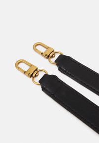 Sorte læderremme med clips i guldfarvet metal, der har en glat tekstur og rene kanter, designet til montering på tasker eller tilbehør.