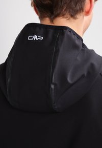 Veste à capuche noire avec une texture douce, présentant un design épuré et des accents brillants le long des coutures. Logo CMP visible au dos.
