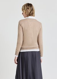 Beige Wolle Pullover mit Rundhalsausschnitt, taillierter Silhouette und geripptem Saum, über einem weißen gestreiften Hemd und einem grauen, plissierten Rock gestylt.
