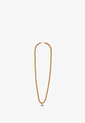 Naszyjnik z okrągłymi bursztynowymi koralikami i małą złotą zawieszką w kształcie słonia na białym tle.