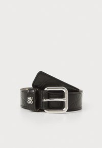 Ceinture en cuir noir avec motif en relief et boucle rectangulaire en métal argenté. Possède un logo de marque sur la boucle.