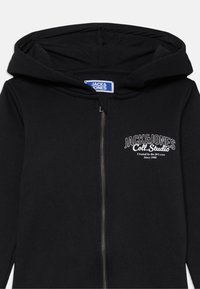 Black zip-up hoodie with a lined hood, featuring a white logo print on the left chest. Fabric is smooth with a soft texture.