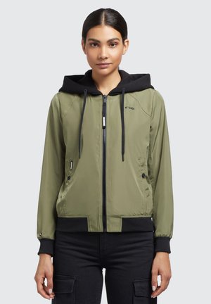 Jachetă bomber verde măslin cu glugă neagră, închidere cu fermoar, buzunare laterale și manșete negre din tricot. Textură netedă cu un design sportiv.