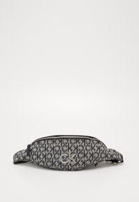 Marsupio a righe in bianco e nero con stampa ripetuta del logo "ck" e emblematico "ck" in metallo sul davanti, dotato di una cerniera superiore e una tracolla regolabile.