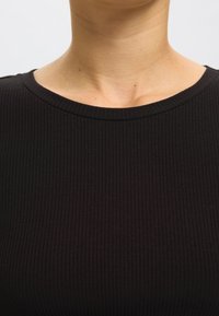 Fekete bordázott felső kerek nyakkivágással és sima textúrával, amely az egész anyagon vízszintes bordázottságot mutat.