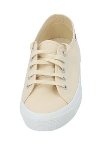 Beige Canvas Sneaker mit runder Zehenpartie, weißer Gummisohle und Metallösen für die Schnürsenkel. Verfügt über eine strukturierte Naht und ein minimalistisches Design.