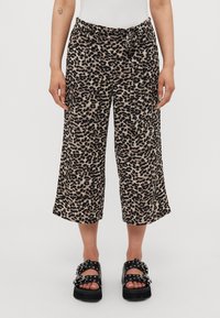 Leopard print cropped pants in beige and black fabric, featuring a tie waist and loose fit, with a smooth texture and wide leg openings.