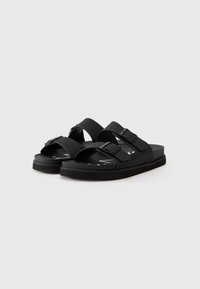 Black rubber sandals with two adjustable straps and buckles, featuring a flat sole and minimalistic design. Soft texture, lightweight construction.