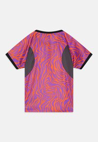 Camisa de manga corta en púrpura con un patrón de rayas de tigre en naranja brillante y detalles de malla negra en los laterales. Textura suave y corte relajado.