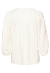 Blusa blanca hecha de tela ligera. Presenta un cuello redondeado, mangas abullonadas y detalles fruncidos en la parte posterior.