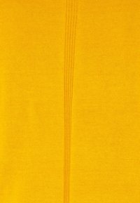 Tissu tricoté de couleur jaune vif avec une texture lisse. Présente une couture centrale avec des points fins et parallèles pour un détail supplémentaire.