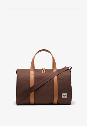 Sac de voyage brun avec des accents en cuir tan et une bandoulière. Dispose de deux poignées supérieures et d'une fermeture éclair avec des accessoires en or. Tissu texturé.
