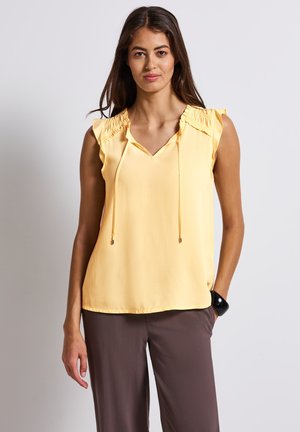 Blusa gialla senza maniche con scollatura a V, dettagli arricciati sulle spalle e lacci regolabili al collo. Tessuto liscio, vestibilità comoda.