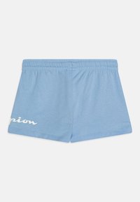 Shorts bleu clair avec un élastique à la taille et un logo partiel "Champion" blanc sur la jambe gauche, présentés à plat sur un fond blanc.