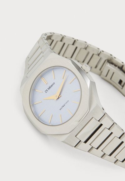 Orologio in acciaio inox argentato con cassa ottagonale, quadrante testurizzato blu chiaro, indici delle ore dorati e design del bracciale a maglia.