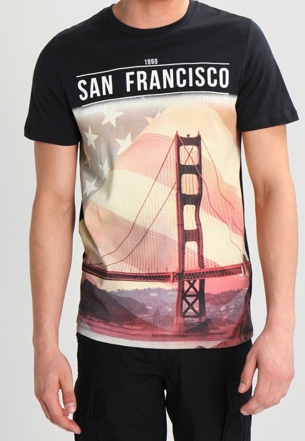 Man wearing black T-shirt featuring Golden Gate Bridge and American flag with "San Francisco 1990" text.