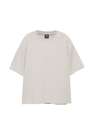 Lysebeige oversized t-shirt med korte ærmer og rund hals, afslappet pasform og synligt brandmærke indeni kraven.