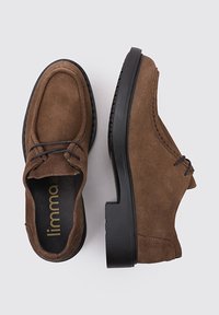 Chaussures en daim marron avec un bout arrondi, semelle en caoutchouc noir et lacets décoratifs. Surface texturée avec des détails de couture ton sur ton.