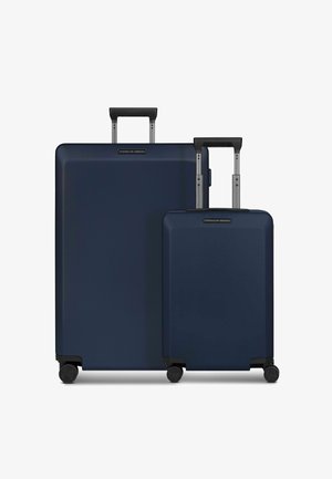 Due valigie coordinate, una grande e una piccola, in materiale rigido di colore blu navy scuro con ruote nere e maniglie estensibili.