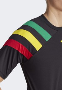 Zwarte sportshirt met korte mouwen, voorzien van groen, geel, rood en zwarte strepen op de schouder. Soepele, lichte stof.