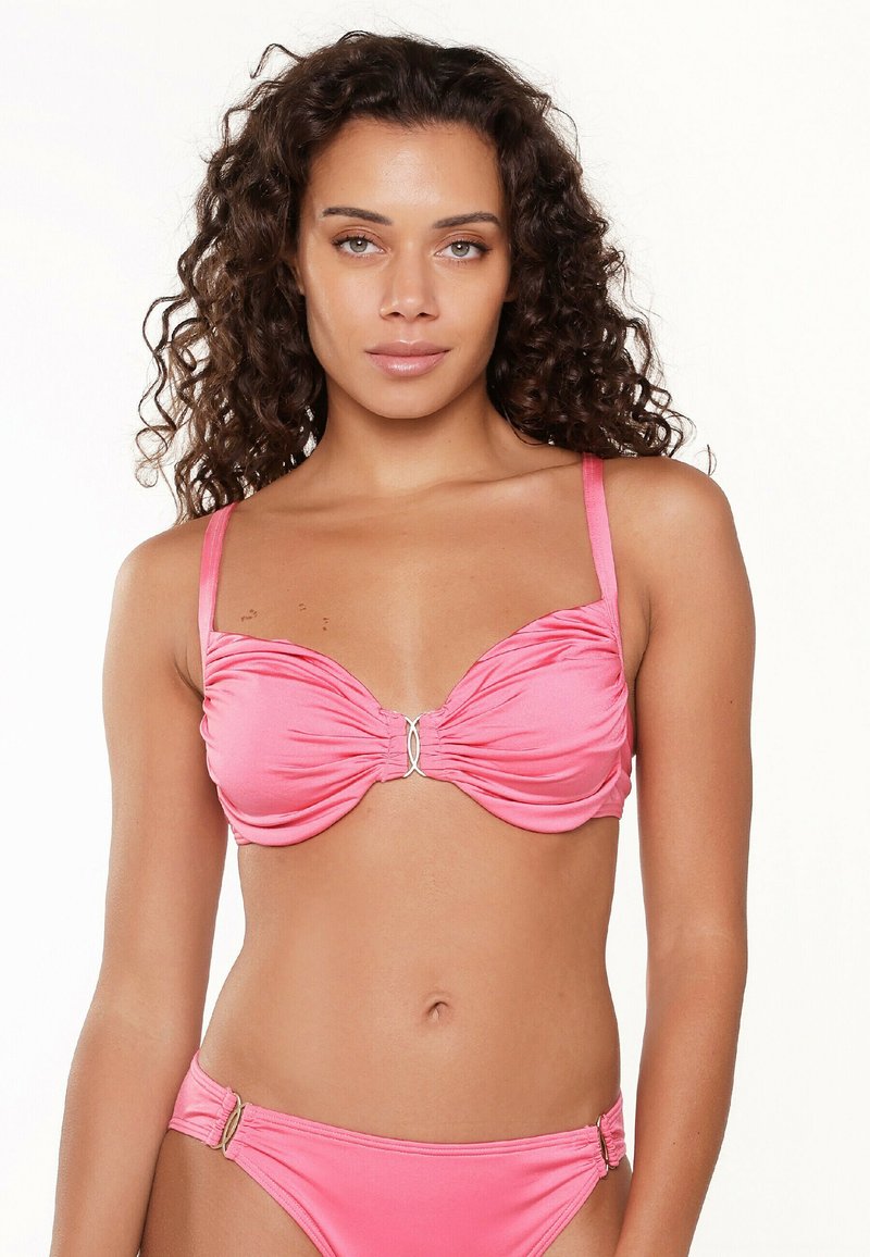 Rosa bikiniset med en rynkad bikiniöverdel med silveraccent och justerbara axelband, tillsammans med en matchande underdel med sidodetaljer i metall.