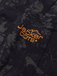 Must musta, millel on tume roheline looduse teema. Sisaldab oranži "Jacker DOOTS" brändingut, sujuvat tekstuuri ja lukuga sulgemist.