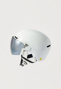 Valge kiiver, millel on voolujooneline disain, hall visir ja ventilatsiooniavad. Näha on MIPS-etikett, mis näitab ohutustehnoloogiat ja tekstuuriga rihma.