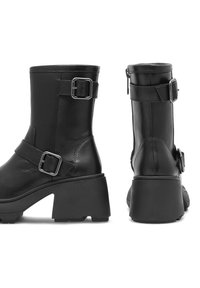 Czarne skórzane botki kostkowe z kwadratowym noskiem, dużym słupkowym obcasem, bocznym zamkiem błyskawicznym oraz regulowanymi paskami z klamrami na cholewie i kostce.