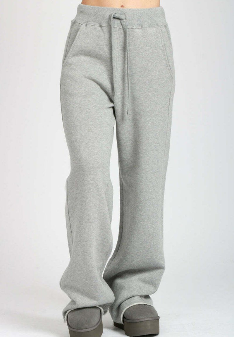 Pantaloni della tuta grigi chiari realizzati in morbido cotone misto. Presentano una vita con cordino, tasche laterali e un design rilassato con gamba dritta.