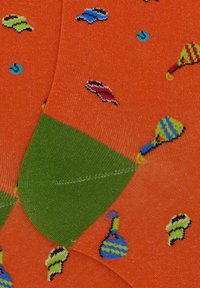 Orange socks with green cuffs, featuring colorful patterns of maracas and small blue dots. Knitted texture, casual design.
