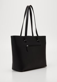 Schwarze Tragetasche aus strukturiertem Synthetikmaterial mit doppelten Griffen, einer Reißverschluss-Vordertasche und einer minimalistischen rechteckigen Form.