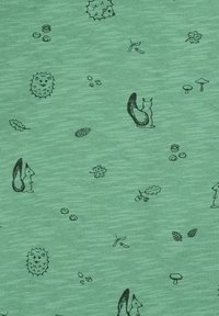 Tessuto verde con una trama sottile che presenta illustrazioni nere di scoiattoli, foglie, funghi e altri elementi naturali.