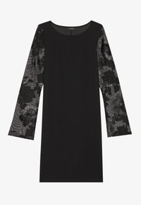 Musta mekko, jossa on pitkät, läpikuultavat kukkakoristeiset hihat. Ominaisuuksiin kuuluu pyöreä kaula-aukko ja tiukka siluetti. Sileä rakenne ja elegantti muotoilu.