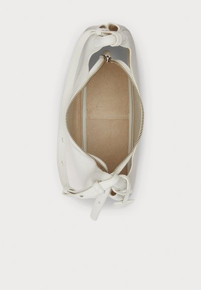 Sac en cuir blanc avec une surface texturée, fermeture éclair et doublure en tissu. Présente un détail noué sur un côté et un intérieur ouvert.