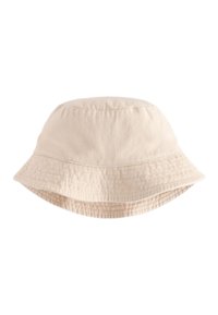Chapeau bob en coton beige avec un bord flexible, un tissu texturé et des détails cousus le long de la couronne et du bord.