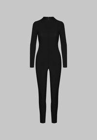 Combinaison noire en tissu extensible, avec des manches longues, un col montant et une fermeture éclair au dos avec un tirette dorée.