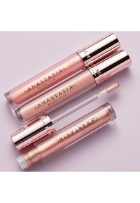 Drei Lipgloss-Tuben in unterschiedlichen Pinktönen. Zwei haben glänzende, metallische roségoldene Kappen, während eine einen klaren, funkelnden Textur hat.