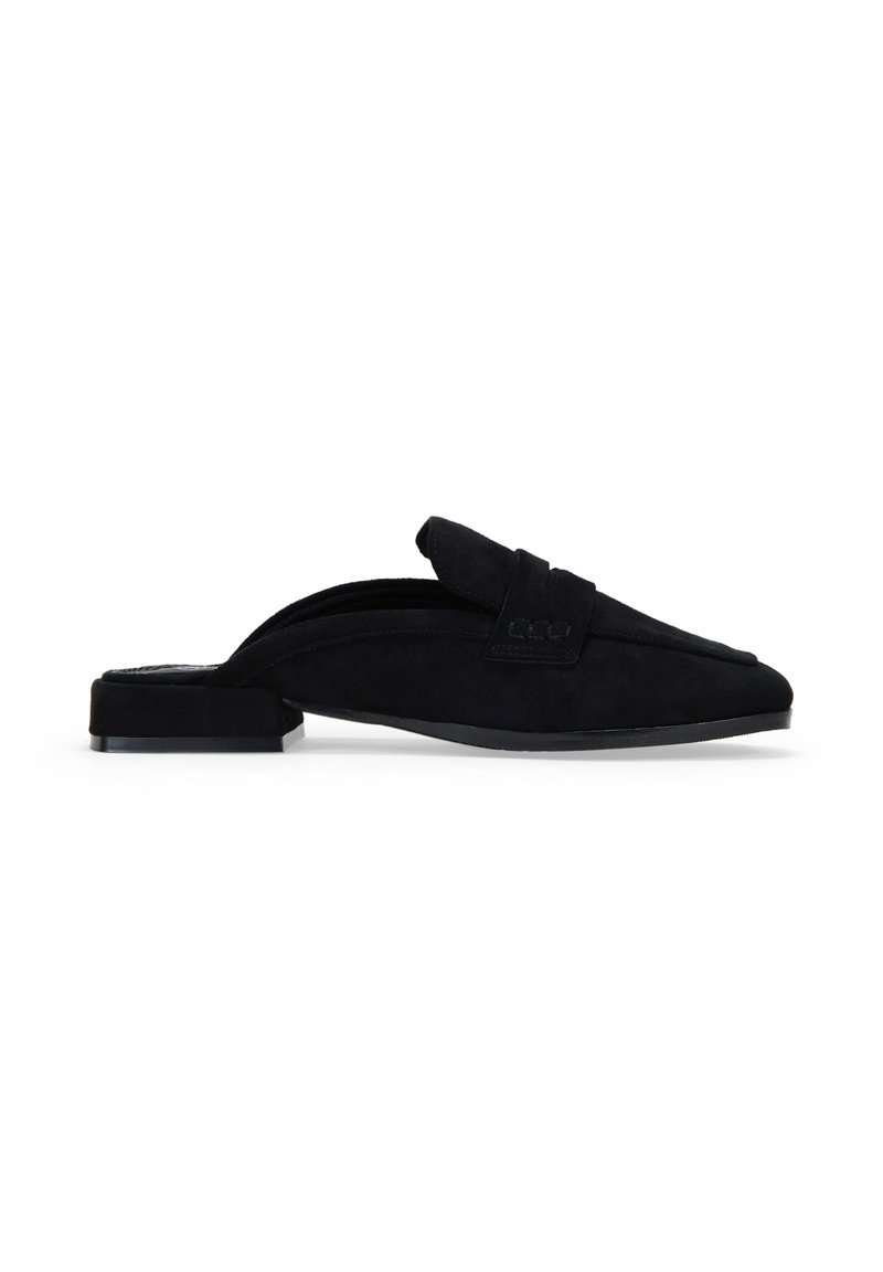 Zapato negro de ante tipo slip-on con tacón plano. Presenta una punta afilada y un diseño de parte superior doblada, proporcionando una textura suave y un perfil elegante.