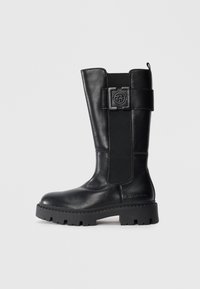 Black knee-high boots made of smooth leather, featuring a belted design accent, elastic side panel, and a rugged sole with deep treads.