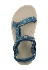 Blå mønstret sandal med en myk, beige såle. Har justerbare stropper og en teksturert såle for komfort. Merkevaren sitt logo er synlig.