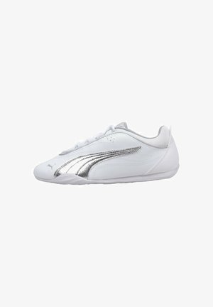 Zapatilla blanca de perfil bajo con una franja plateada del logo Puma en el lateral, cordones blancos y una suela de goma delgada.