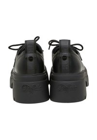 Scarpe in pelle nere con suola platform, punta arrotondata, suola in gomma spessa e tacco testurizzato. Presentano un dettaglio del logo sul retro e lacci nella parte superiore.